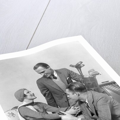 1930s two men one woman golf clubs bag smiling talking sitting bamboo chair man smoking pipe by Anonymous