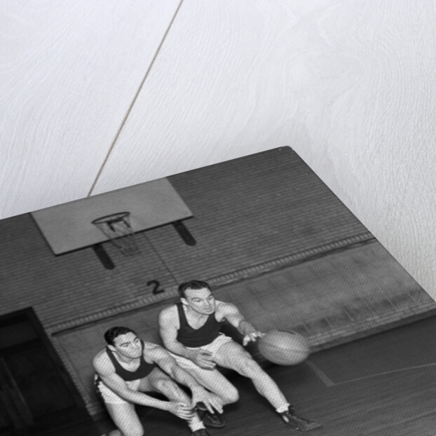 1930s two boys playing basketball inside court dribbling basketball by Anonymous