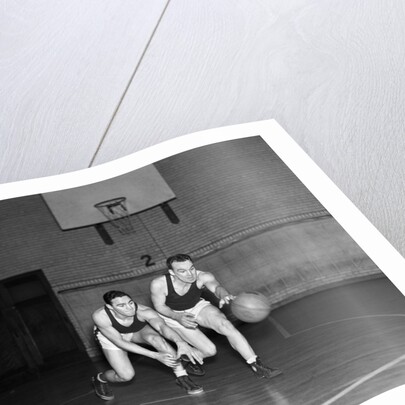 1930s two boys playing basketball inside court dribbling basketball by Anonymous