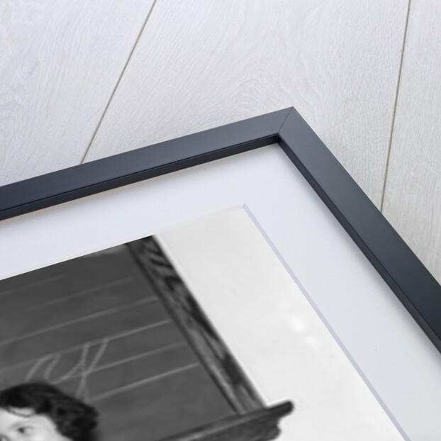 1930s 1940s smiling girl sitting at desk raising her hand by Anonymous