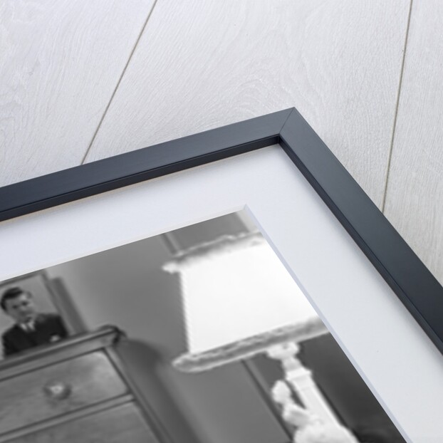 1940s fully dressed smiling woman laying on her bed with her legs up reading a letter in her bedroom by Anonymous