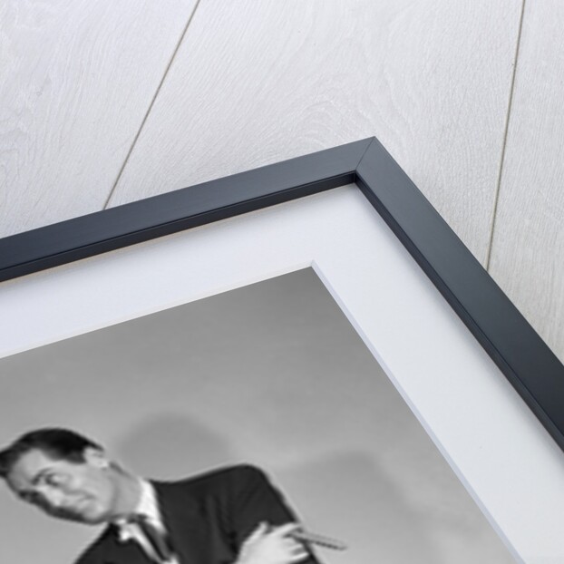 1950s couple man woman shopping cart reviewing grocery list man has cigar in hand by Anonymous