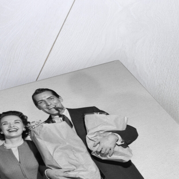 1950s couple smiling woman man carrying grocery bags smoking cigar looking at camera by Anonymous