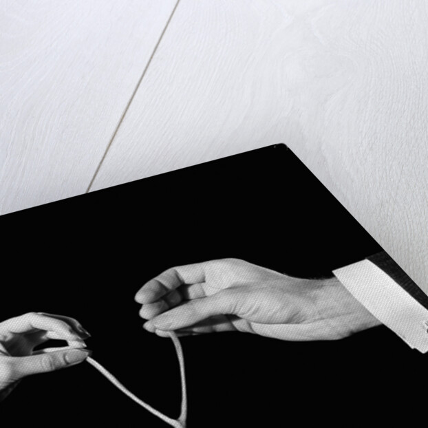 1940s man's & woman's hands pulling on either side of wishbone by Anonymous