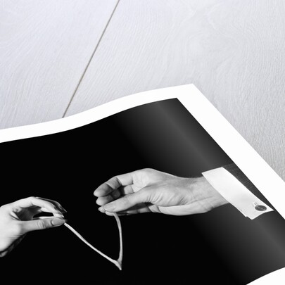 1940s man's & woman's hands pulling on either side of wishbone by Anonymous
