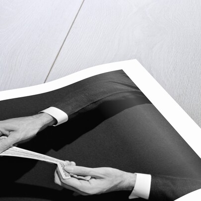 1930s 1940s man's hands symbolic money stretching a dollar by Anonymous