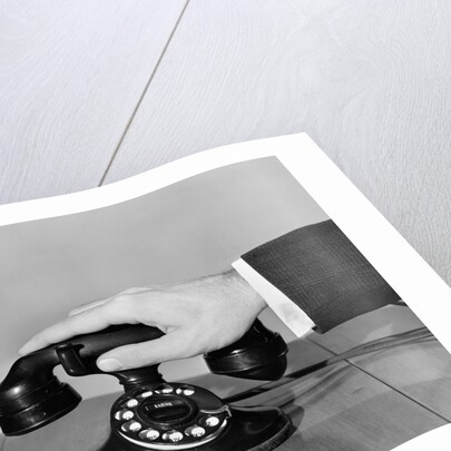 1930s 1940s man's hand on telephone by Anonymous