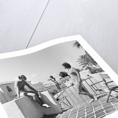 1930s man woman wearing bathing suits on terrace overlooking swimming pool woman on diving board by Anonymous