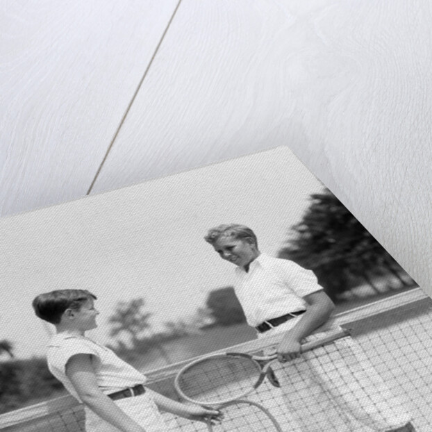 1920s 1930s two boys tennis match holding rackets measuring net height by Anonymous