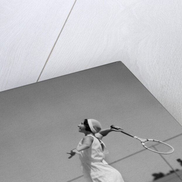 1930s woman playing tennis about to hit ball with racket by Anonymous