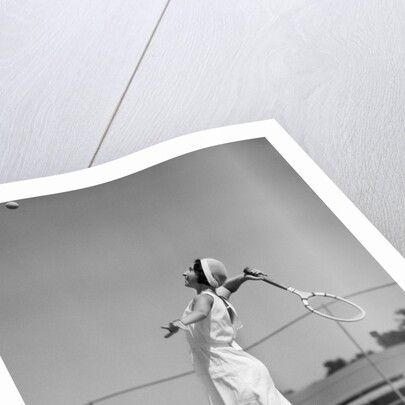 1930s woman playing tennis about to hit ball with racket by Anonymous