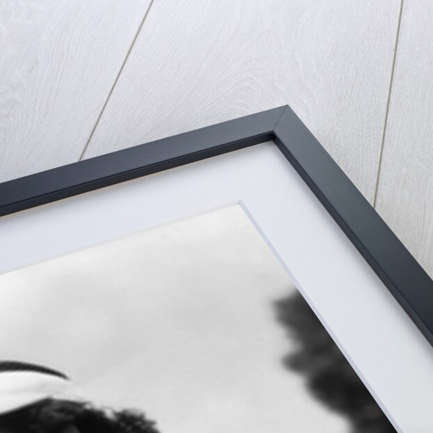 1930s woman in polka dot halter top shorts & sun visor holding a tennis ball & racket by Anonymous