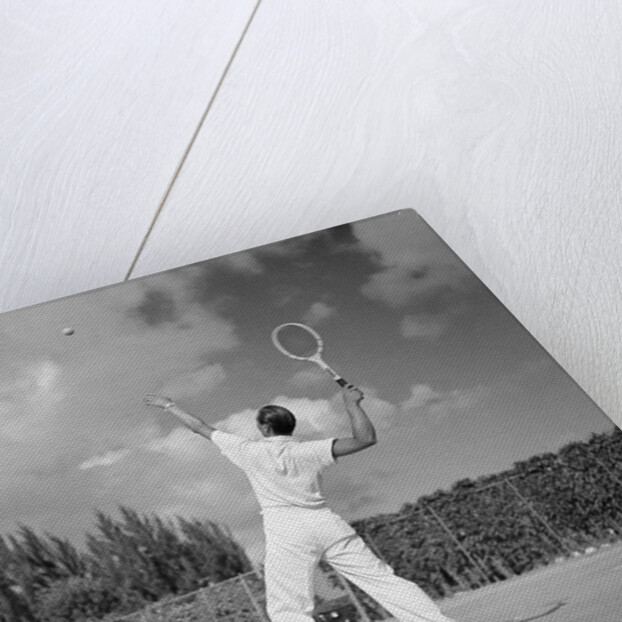 1930s back view of man playing tennis about to hit the ball summer outdoor by Anonymous
