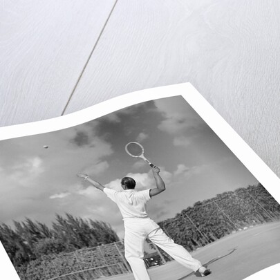 1930s back view of man playing tennis about to hit the ball summer outdoor by Anonymous
