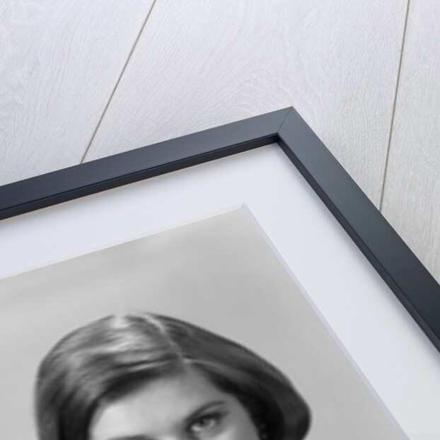 1960s formally elegantly dressed young woman looking at camera with a cigarette holder wearing long white gloves by Anonymous