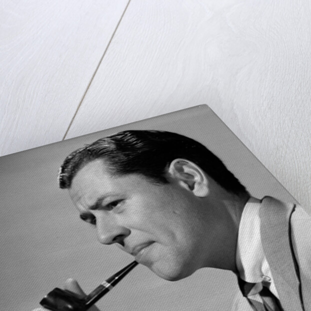 1950s frowning businessman in jacket and tie smoking a pipe by Anonymous