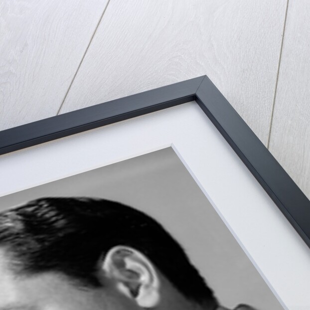 1950s frowning businessman in jacket and tie smoking a pipe by Anonymous