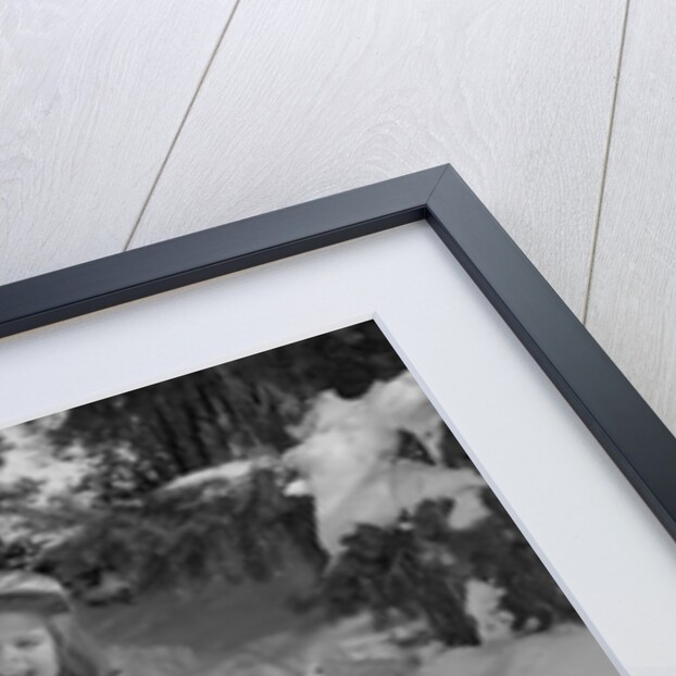 1950s 1960s smiling boy and girl building a snowman together in snowy woods by Anonymous