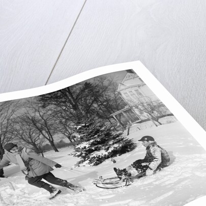 1950s woman mother pulling boy son on sled in winter by Anonymous