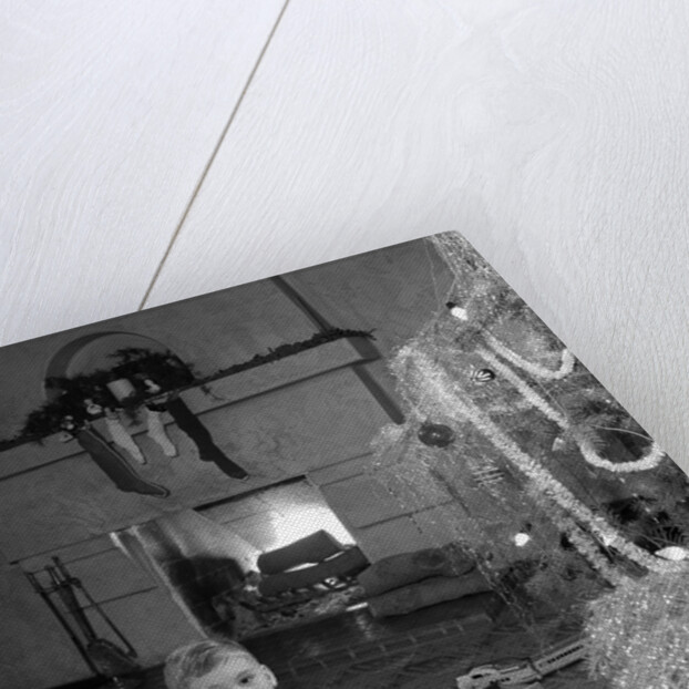 1950s little boy playing toy drum by christmas tree and fireplace looking at camera by Anonymous