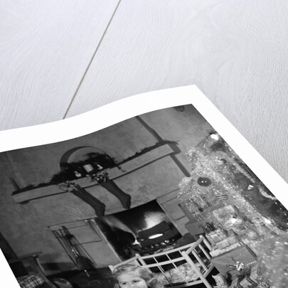 1950s smiling little girl christmas tree talking on toy telephone by Anonymous