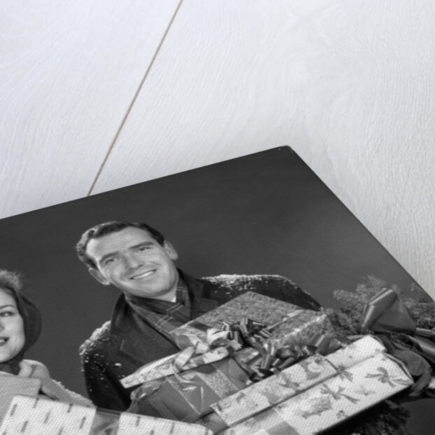 1960s smiling couple man and woman holding wrapped christmas presents and packages by Anonymous