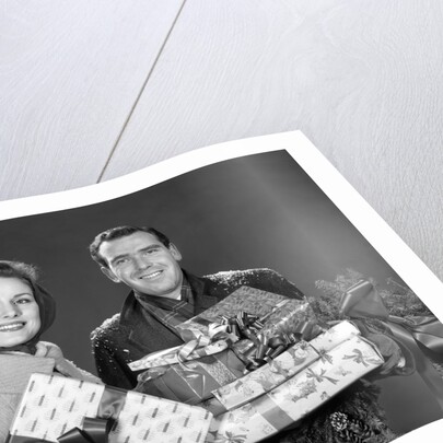 1960s smiling couple man and woman holding wrapped christmas presents and packages by Anonymous