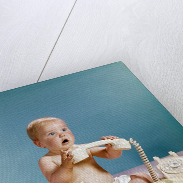1960s baby surprised facial expression holding telephone hand set over yellow pages phone book directory by Anonymous