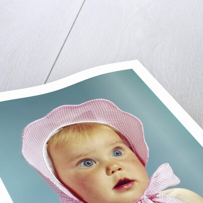 1960s Very Cute Blond Blue Eyed Baby Wearing Red White Checked Bonnet Tied In Bow At Chin by Anonymous