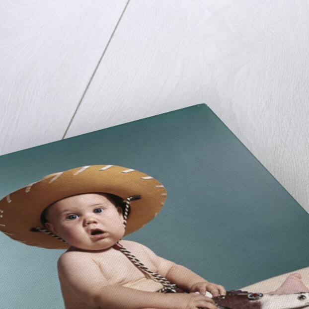 1960s Baby Wearing Cowboy Costume With Funny Facial Expression Looking At Camera by Anonymous