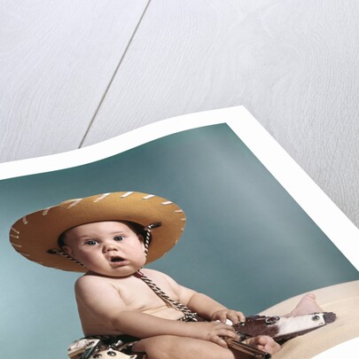 1960s Baby Wearing Cowboy Costume With Funny Facial Expression Looking At Camera by Anonymous