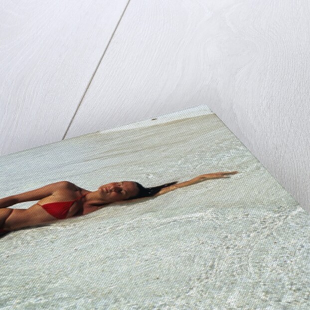 1990s Woman In Red Bikini Lying In Shallow Water On The Beach by Anonymous
