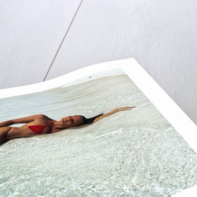 1990s Woman In Red Bikini Lying In Shallow Water On The Beach by Anonymous