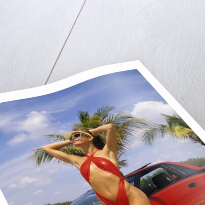 1980s Woman In Red Swimsuit In Front Of Red Sports Car by Anonymous