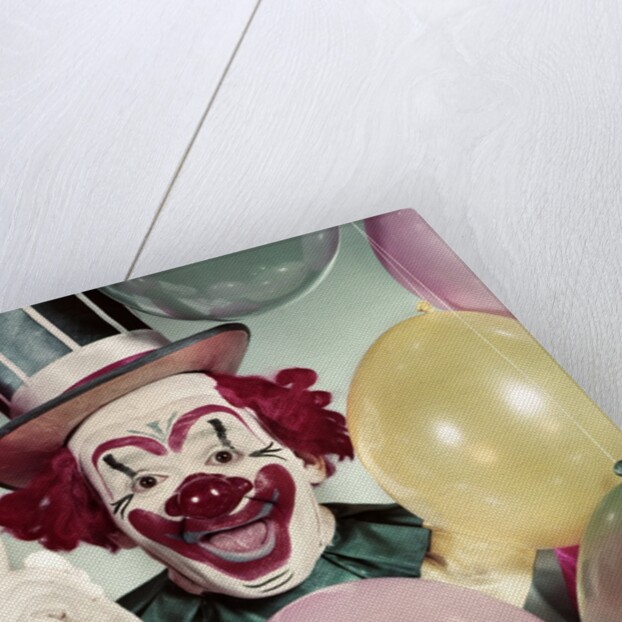 1950s Circus Clown Portrait Smiling Amid Balloons Pointing Up Looking At Camera by Anonymous