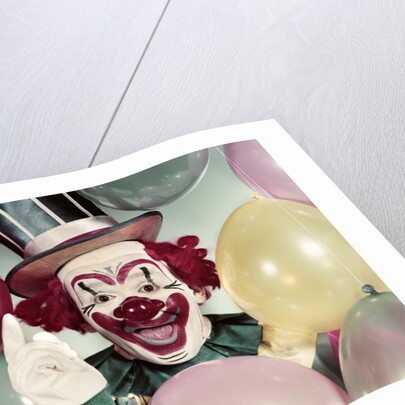 1950s Circus Clown Portrait Smiling Amid Balloons Pointing Up Looking At Camera by Anonymous
