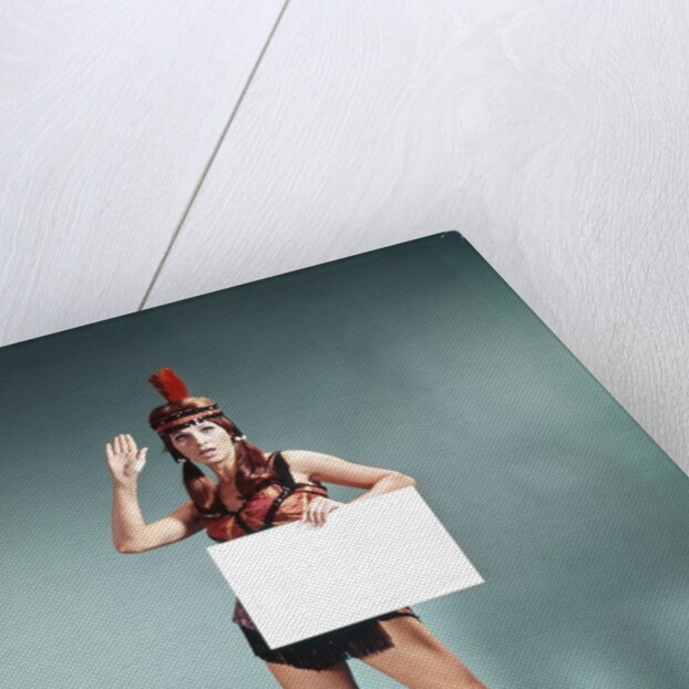 1960s 1970s Character Woman Wearing Native American Feather Headdress Making How Gesture Holding Blank Sign Looking At Camera by Anonymous