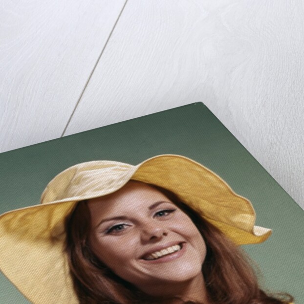 1970s Smiling Young Woman Wearing Yellow Floppy Brim Hat And Blouse With Pink Beads Looking At Camera by Anonymous