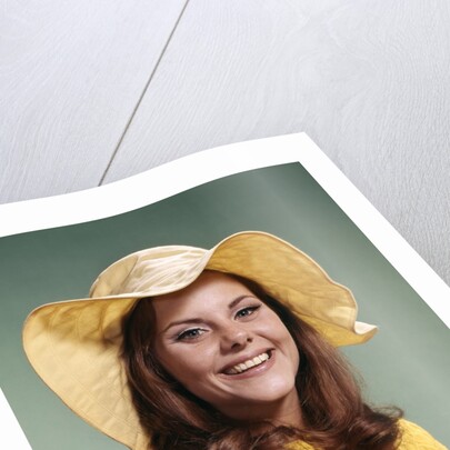 1970s Smiling Young Woman Wearing Yellow Floppy Brim Hat And Blouse With Pink Beads Looking At Camera by Anonymous