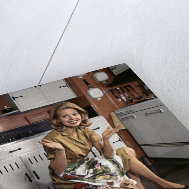 1960s Young Smiling Blond Housewife Sitting On Top Of Laundry Basket Kitchen by Anonymous