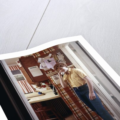 1970s Teenage Boy Talking On Kitchen Wall Phone Telephone by Anonymous