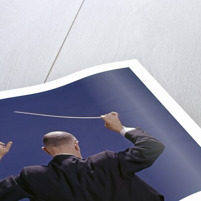 1950s 1960s 1970s View Of Back Of Bald Man Conducting A Symphony Orchestra by Anonymous