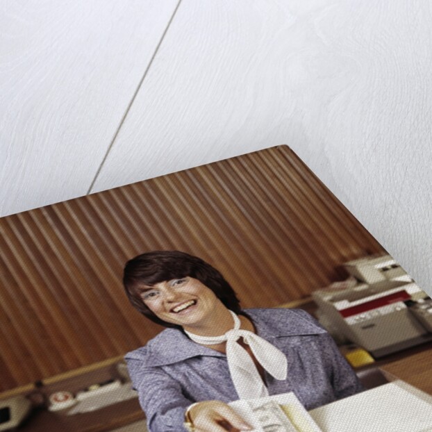 1970s Smiling Woman Bank Teller Handing Cash Over Counter by Anonymous