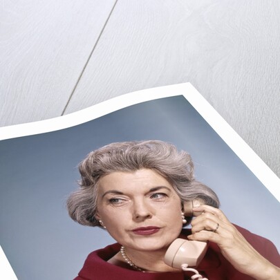 1960s Senior Middle Aged Woman Red Blouse Serious Expression Talking On Telephone by Anonymous