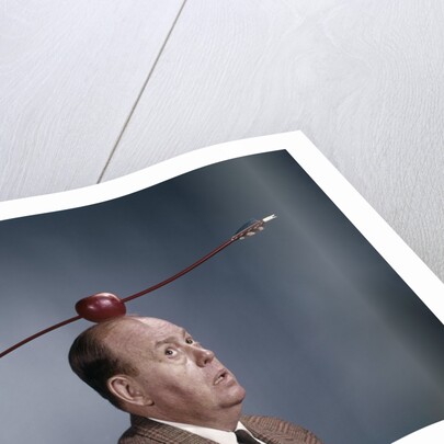 1960s Anxious Nervous Man Looking Up At Arrow Shot Through An Apple Sitting On Top Of His Head by Anonymous