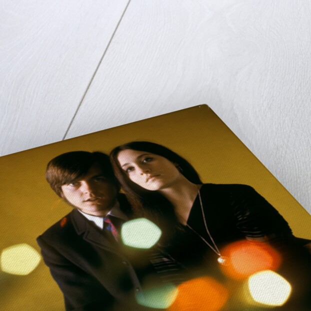 1960s 1970s Young Couple Man Woman Head To Head Dressed In Black Look At Camera Mod Style Serious Expression Blur Lights by Anonymous