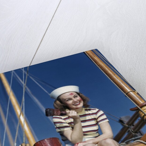 1940s Smiling Woman Wearing Nautical Sailor Outfit And Hat Sitting On Edge Of Boat Holding Paint Brush by Anonymous