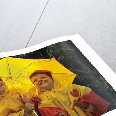 1990s Two Laughing Young Girls Holding A Yellow Umbrella And Wearing Yellow Rain Ponchos by Anonymous