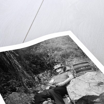 1950s Lazy Fisherman Lying Back On Rock With Hat Pulled Over Eyes Fishing In Creek by Anonymous