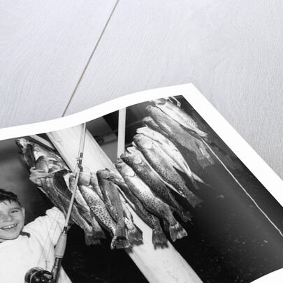 1950s Smiling Boy Proudly Displaying His Fish Catch Looking At Camera by Anonymous